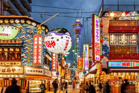 Street view of many lit up Japanese business signs 
