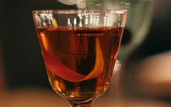 Glass of liqueur with orange peel inside