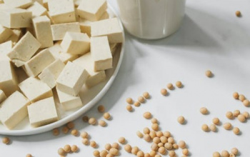 Soy products on a table including soy milk, tofu, and soy beans